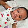 Ariah is registered to the contest to win money with this photo: baby, child, smiling, face, cute, infant, lying_down, blanket, clothing, pattern, fruit_print, minnie_mouse, happy, portrait, skin, head, eyes, person, soft, toddler