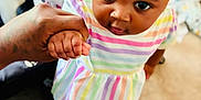 Ariah joined the competition — help win amazing prizes! toddler, child, holding_hand, colorful_dress, headband, indoor, carpet, footwear, person, cute, baby, looking_up, hand, adult_hand, blurred_background, striped_clothing, curious, walking, young_child, close_up