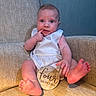 Hank is registered to the contest to win money with this photo: baby, infant, child, four_months, milestone, armchair, furniture, beige, clothing, cute, portrait, sitting, hand, foot, toes, face, expression, indoor, light, sign