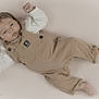 Tiago participe au concours pour gagner de l'argent avec cette photo : baby, infant, overalls, clothing, lying_down, fist, face, skin, person, portrait, cute, neutral_background, soft_texture, young_child, small_feet, baby_garment, expression, child, newborn, photography