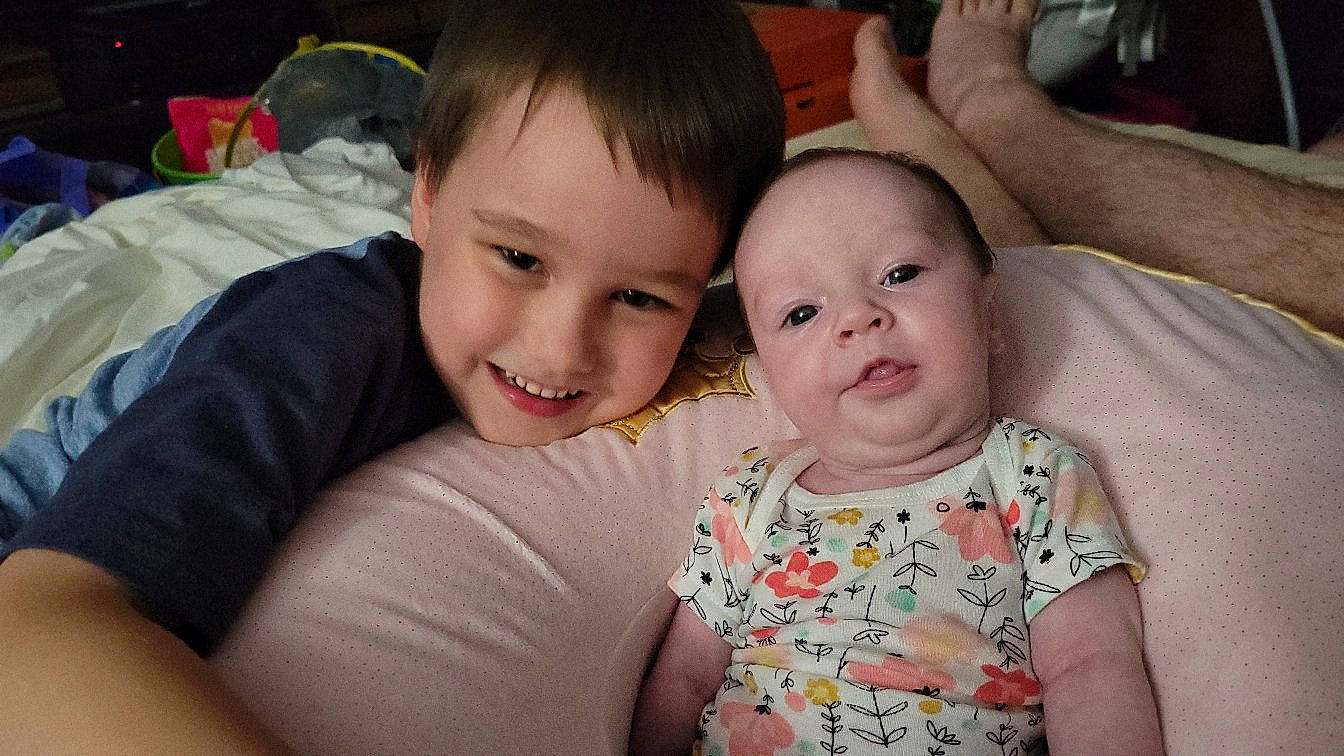 Juliet is registered to the contest to win money with this photo: arm, baby_toddler_clothing, cheek, chin, comfort, dress, eye, eyebrow, face, facial_expression, hair, happy, human_body, interaction, iris, joy, lip, mouth, nose, person