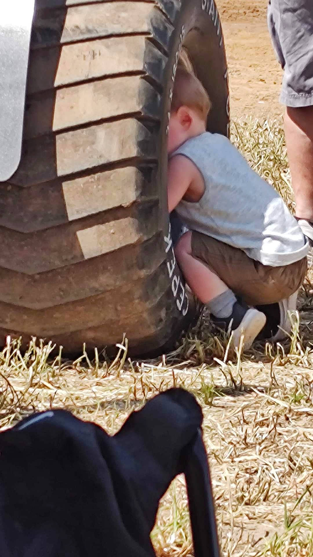 Kol is registered to the contest to win money with this photo: automotive_tire, comfort, foot, fun, grass, grass_family, human_leg, knee, leaf, leisure, people_in_nature, shoe, shorts, sitting, soil, spring, thigh, toddler, trunk, wood