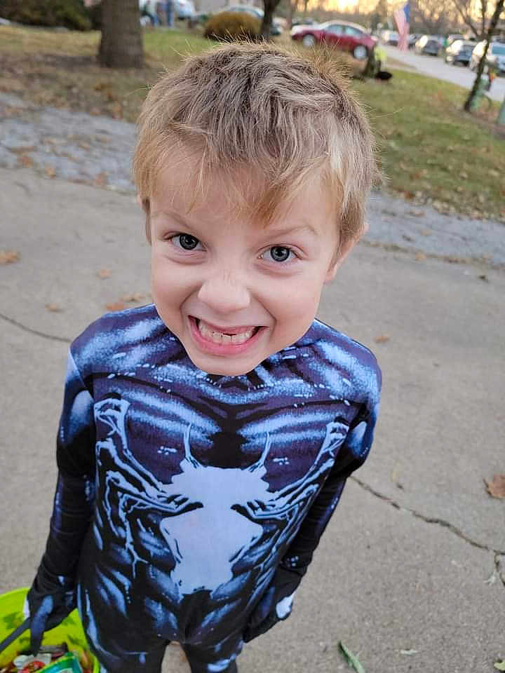 James joined the competition — help win amazing prizes! child, boy, costume, halloween, candy, bucket, sidewalk, outdoor, smiling, face, blue, black, gloves, spooky, fun, holiday, daytime, grass, trees, casual