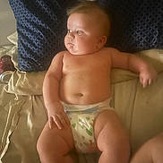 Zabel Carroll is registered to the contest to win money with this photo: baby, diaper, bed, pillow, blue_pillow, beige_sheets, can, black_cherry_soda, chubby, infant, skin, person, lying_down, indoors, relaxed, cute, soft_light, expression, head, arm