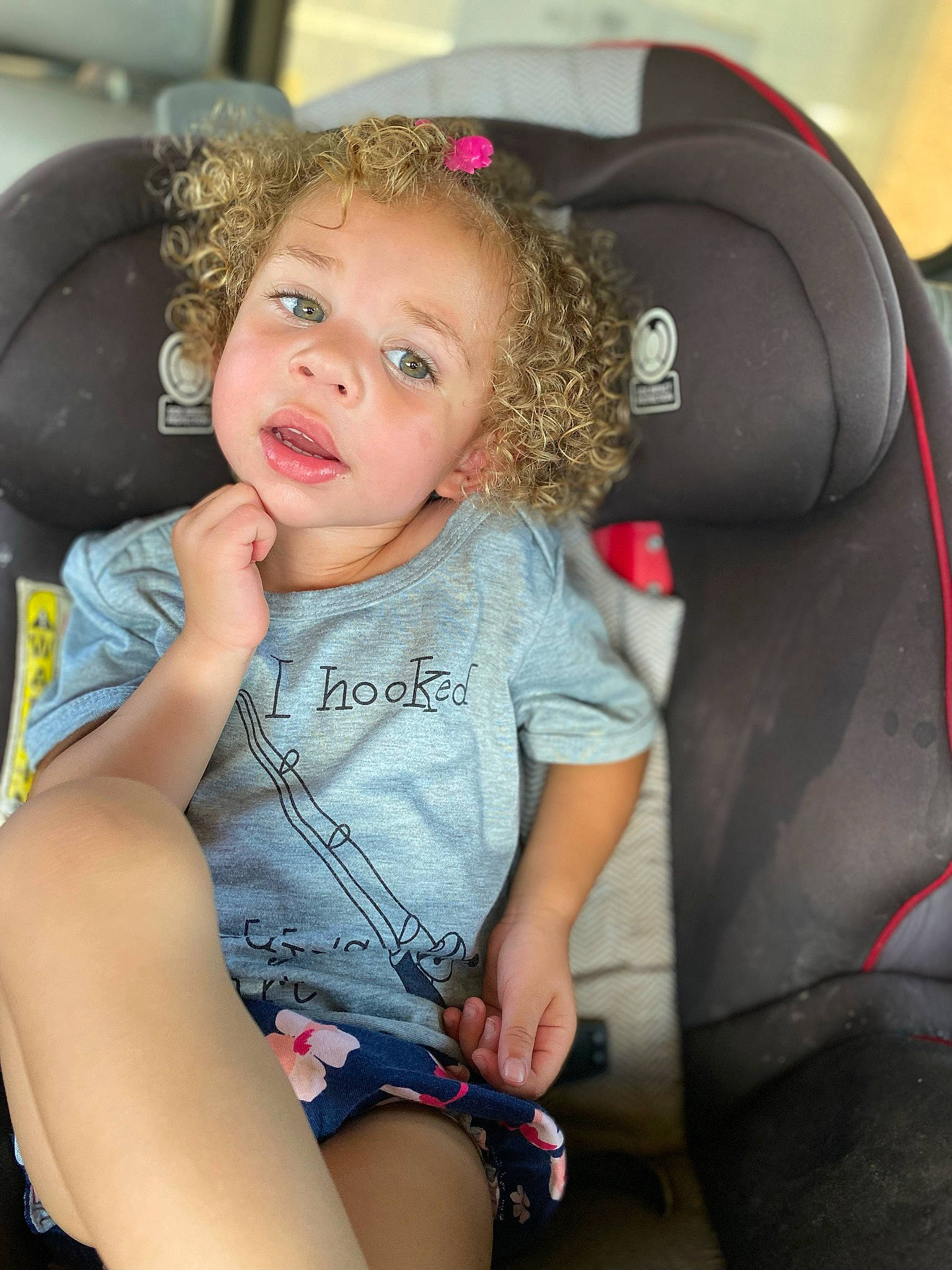 Riley is registered to the contest to win money with this photo: auto_part, automotive_design, baby_toddler_clothing, car_seat, car_seat_cover, child, clothing, comfort, face, fun, hairstyle, happy, leg, motor_vehicle, mouth, person, skin, steering_wheel, thigh, toddler