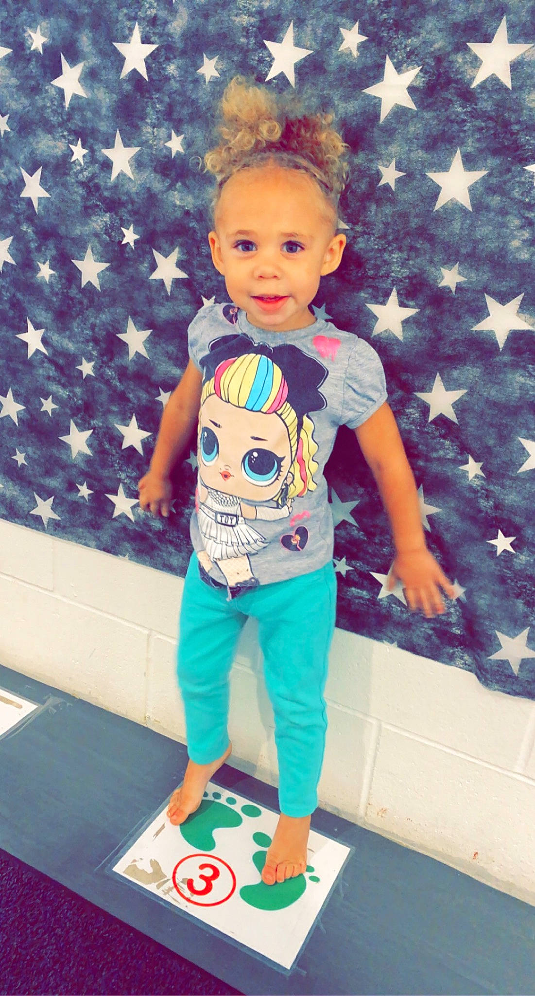 Riley is registered to the contest to win money with this photo: active_pants, baby_toddler_clothing, blue, electric_blue, event, face, happy, pattern, person, photograph, pink, sleeve, smile, snapshot, sportswear, standing, t_shirt, textile, toddler, waist