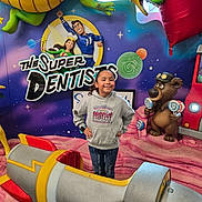Maryfer is registered to the contest to win money with this photo: background, bear, cartoon, child, colorful, dentist_theme, dragon, family_friendly, hands_on_hips, hoodie, indoor, jeans, lollipop, mural, play_area, portrait, pose, poster, rocket, smiling
