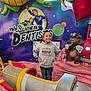 background, bear, cartoon, child, colorful, dentist_theme, dragon, family_friendly, hands_on_hips, hoodie, indoor, jeans, lollipop, mural, play_area, portrait, pose, poster, rocket, smiling