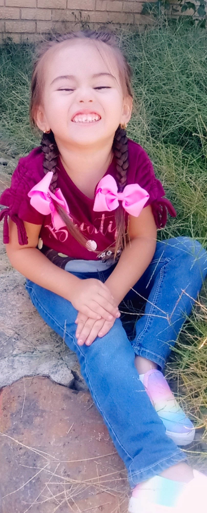 Athena is registered to the contest to win money with this photo: arm, child, child_model, cool, denim, electric_blue, grass, jeans, joy, leg, long_hair, neck, pattern, person, pink, plant, play, sitting, skin, smile