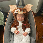Reny joined the competition — help win amazing prizes! baby, infant, child, costume, gremlin_costume, plush, hood, big_ears, seat, infant_seat, smile, cute, indoor, portrait, brown_fur, white_fur, hands, cozy, wood_floor, eyes