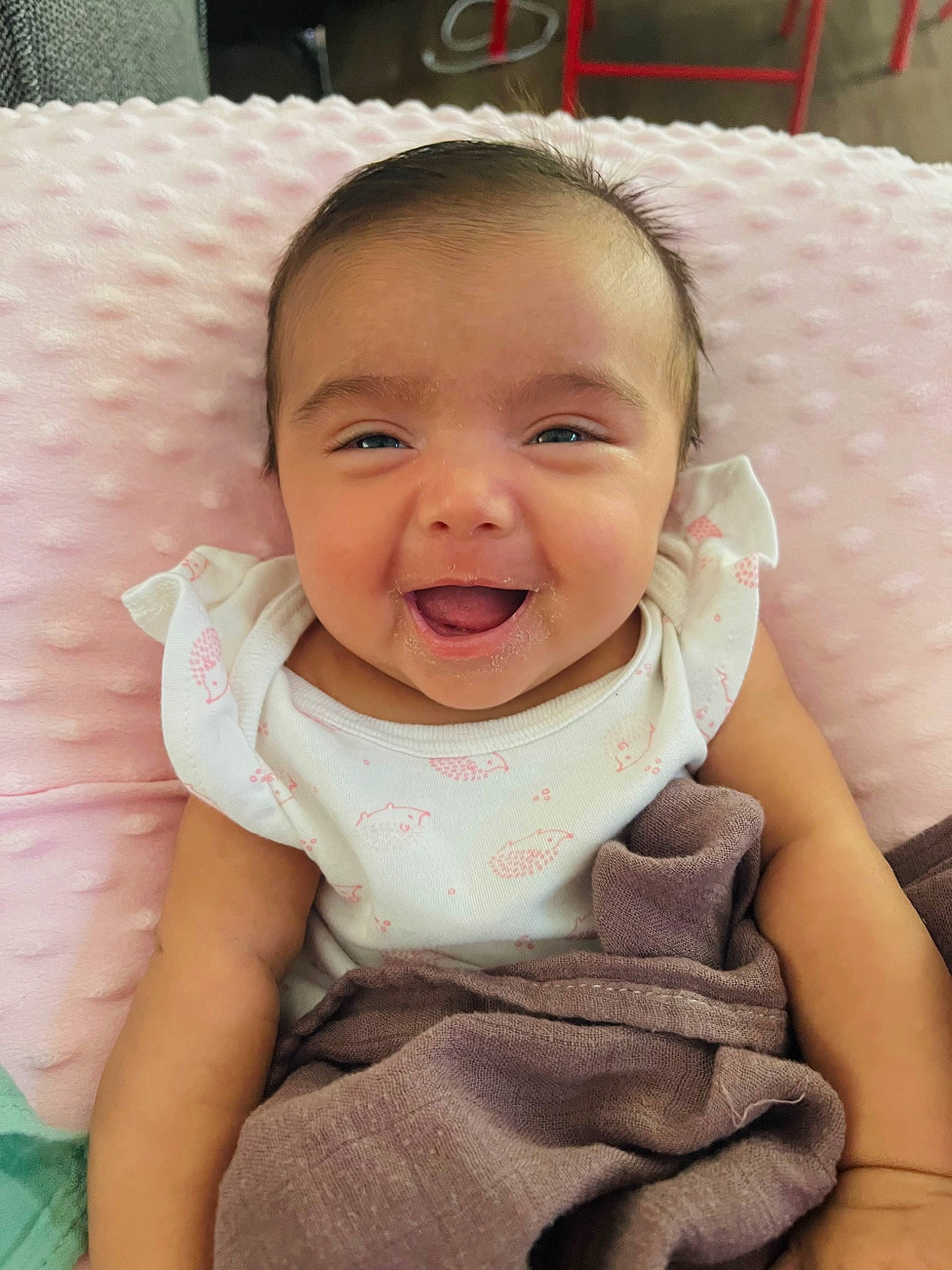 Camila is registered to the contest to win money with this photo: baby, baby_products, baby_toddler_clothing, cheek, child, collar, comfort, eyelash, happy, head, iris, linens, lip, nose, person, pink, sitting, skin, sleeve, smile