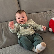 Telyo participe au concours pour gagner de l'argent avec cette photo : baby, child, smiling, couch, sofa, indoor, sweater, pants, sock, happy, cute, infant, furniture, living_room, plush_toy, wallpaper, green, comfort, portrait, person