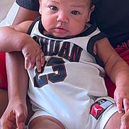 Lionel joined the competition — help win amazing prizes! adult, baby, basketball_jersey, bed, child, close_up, curious, curly_hair, family, hands, held, indoors, infant, number_23, photography, portrait, safe, sitting, smiling, sportswear