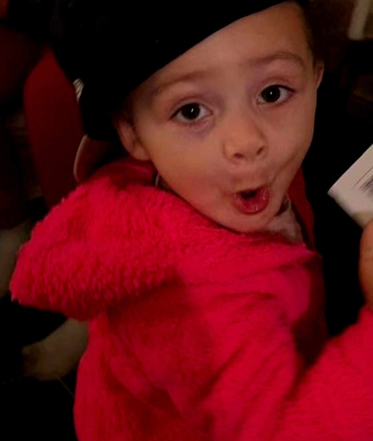 Brealyn is registered to the contest to win money with this photo: child, face, hat, pink_jacket, expression, indoor, person, clothing, hand, portrait, cute, young, looking_at_camera, holding, fuzzy_texture, warm_clothing, playful, wide_eyes, mouth_open, fun