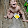 Alexia joined the competition — help win amazing prizes! bare_chest, bowl, child, cute, diaper, floor, fun, happy, home, indoor, laughing, messy, person, play_stool, sitting, smiling, toddler, wood_floor, yellow_food, young_child