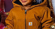 Mylah is registered to the contest to win money with this photo: child, smiling, braids, beads, brown_jacket, purse, gift_box, golden_furniture, portrait, indoor, cute, fashion, accessory, happy, young_child, person, holiday, decor, cozy, cute_expression