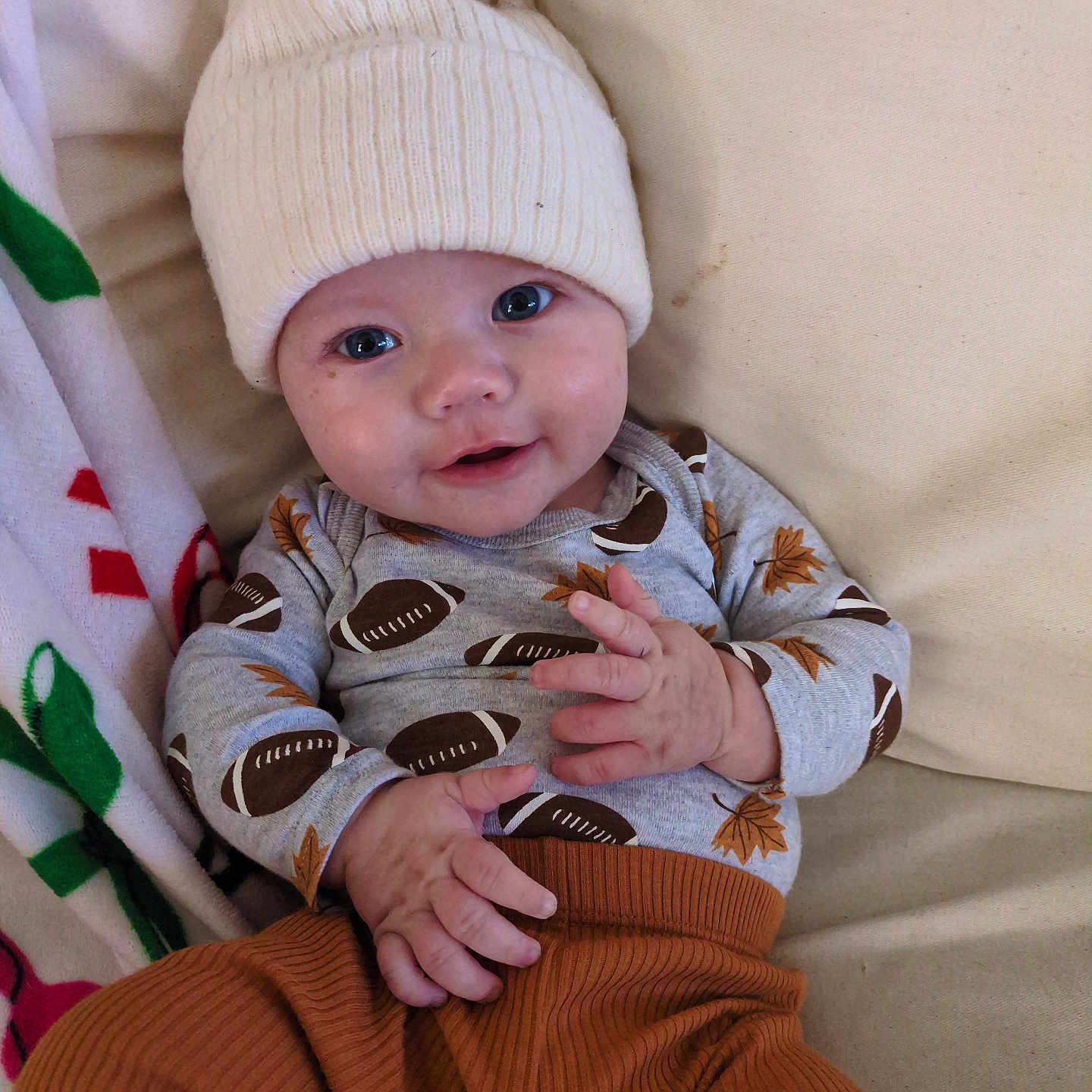 Trenton joined the competition — help win amazing prizes! apparel, baby, blanket, child, clothing, couch, cozy, cute, eyewear, face, hands, happy, hat, headwear, indoors, infant, person, portrait, sitting, smile