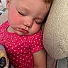 toddler, child, sleeping, pink_shirt, hearts_pattern, plush_toy, cushion, rosy_cheeks, peaceful, closeup, face, eyelashes, indoor, resting, cozy, soft_texture, cute, portrait, young_child, nap_time