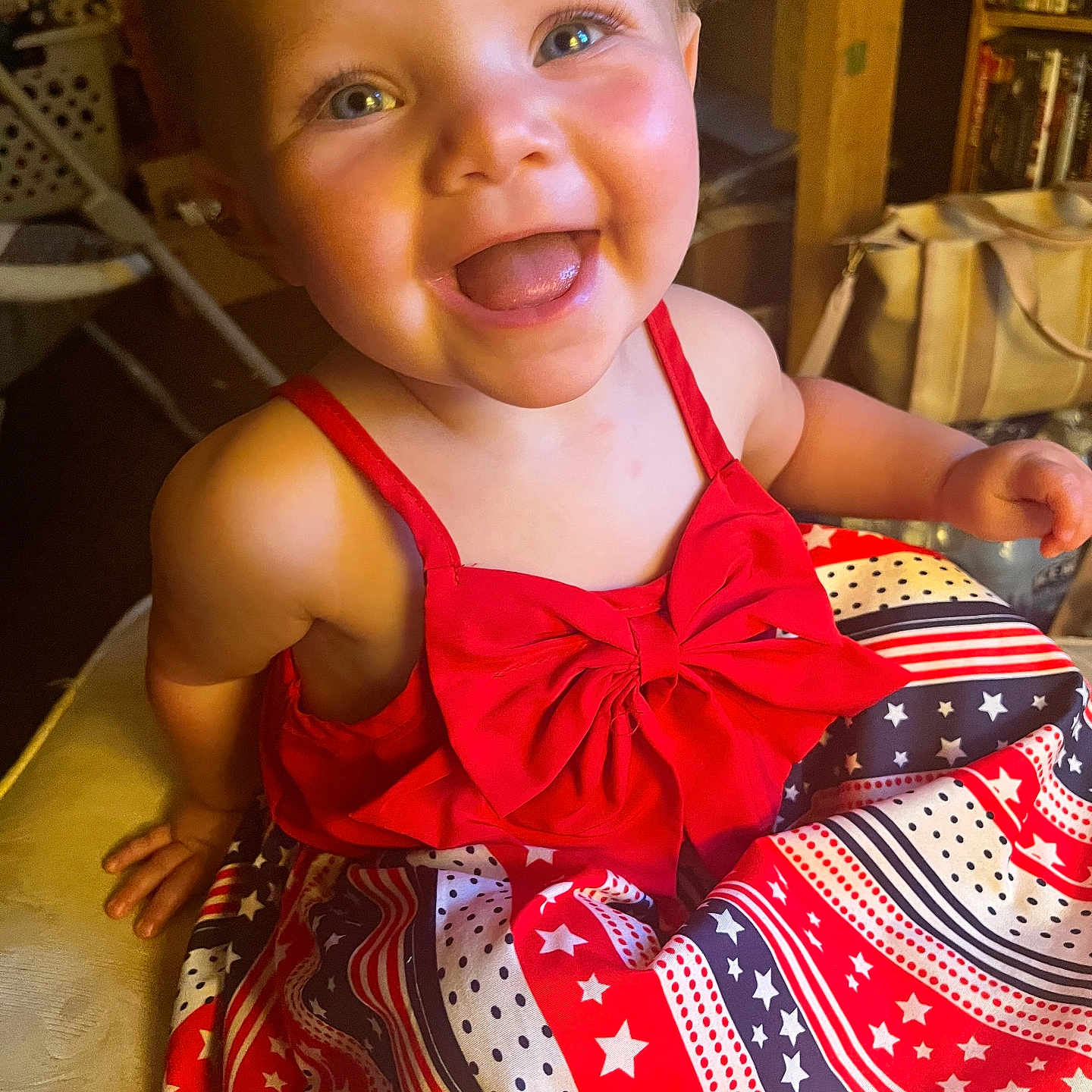 Drew joined the competition — help win amazing prizes! toddler, child, smiling, red_dress, stars, stripes, indoor, happy, face, person, cute, baby, patterned_clothing, portrait, colorful, playful, young_child, sitting, bright, closeup