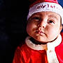 Atreus joined the competition — help win amazing prizes! baby, infant, face, child, christmas_hat, red_clothing, festive, holiday, cute, portrait, soft_light, closeup, warm, smile, expression, buttoned_clothing, indoors, young, headwear, adorable