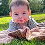 baby, child, smiling, blanket, grass, outdoor, nature, sunlight, greenery, portrait, cute, happy, infant, toddler, face, young_child, relaxing, casual_clothing, daytime, scenery