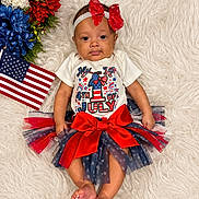 Zola joined the competition — help win amazing prizes! baby, infant, tutu, red_bow, headband, american_flag, flowers, white_rug, patriotic, 4th_of_july, cute, festive, clothing, portrait, smiling, celebration, holiday, toddler, lying_down, indoor
