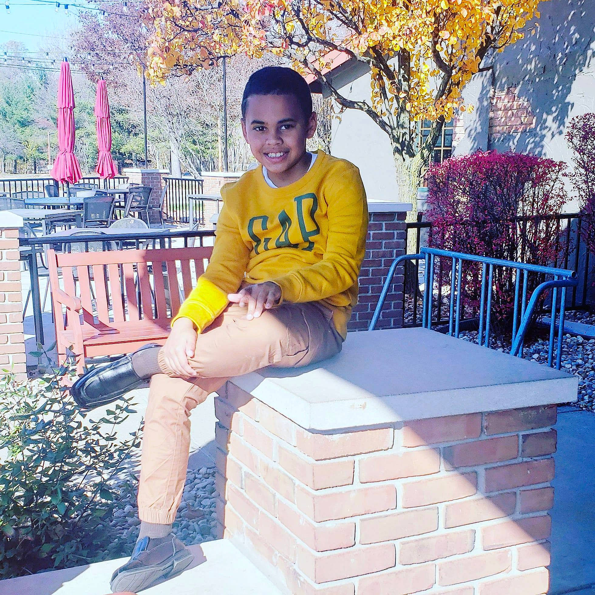 Noah joined the competition — help win amazing prizes! ankle, beauty, brick, brickwork, child_model, denim, foot, happy, human_leg, joy, knee, lap, laugh, outdoor_furniture, person, photo_shoot, purple, sitting, spring, stairs