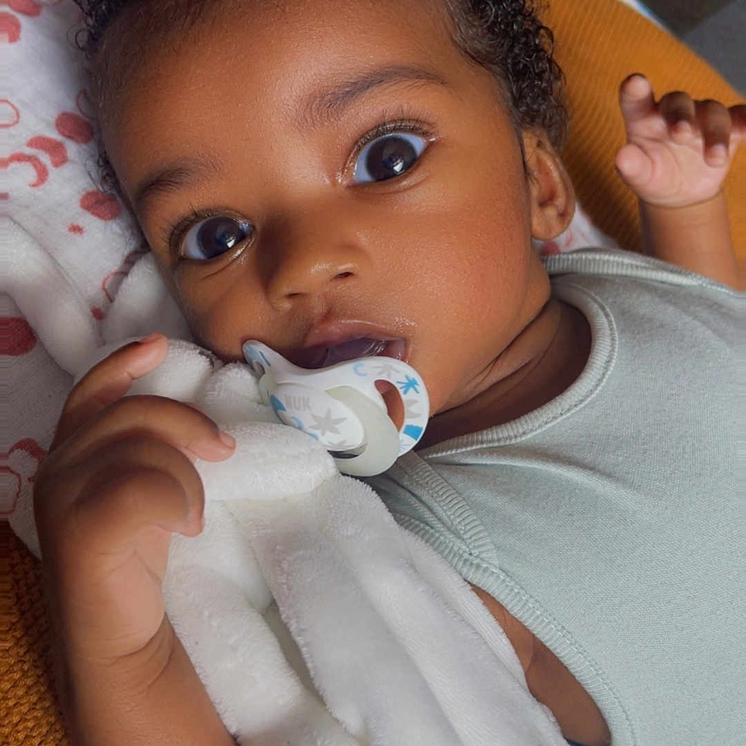 Aaron a rejoint le concours — aidez-le/la à gagner de superbes lots ! baby, blanket, child, close_up, clothing, comfort, curly_hair, cute, expression, hand, indoors, infant, lying_down, pacifier, portrait, skin, soft_texture, toddler, wide_eyes, young_child