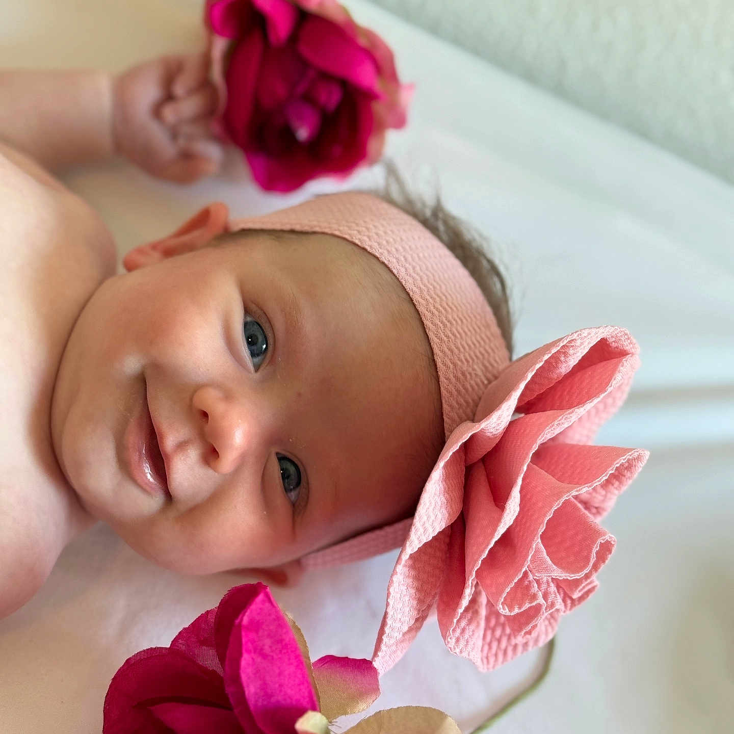 Addison joined the competition — help win amazing prizes! baby, blanket, blue_eyes, child, closeup, cute, face, flower, happy, headband, indoors, infant, lying_down, newborn, person, pink, portrait, skin, smile, soft