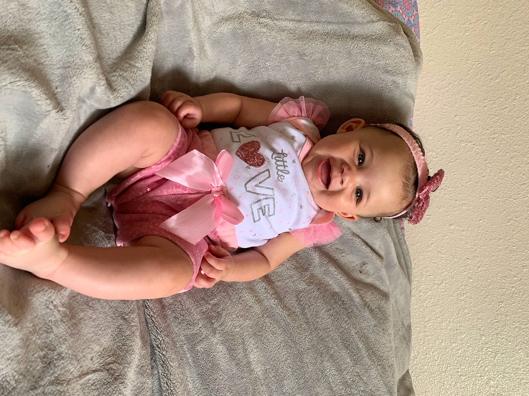 Imani joined the competition — help win amazing prizes! arm, baby, baby_toddler_clothing, cheek, comfort, dress, eye, face, facial_expression, finger, glasses, hand, head, human_body, leg, mammal, person, pink, product, skin