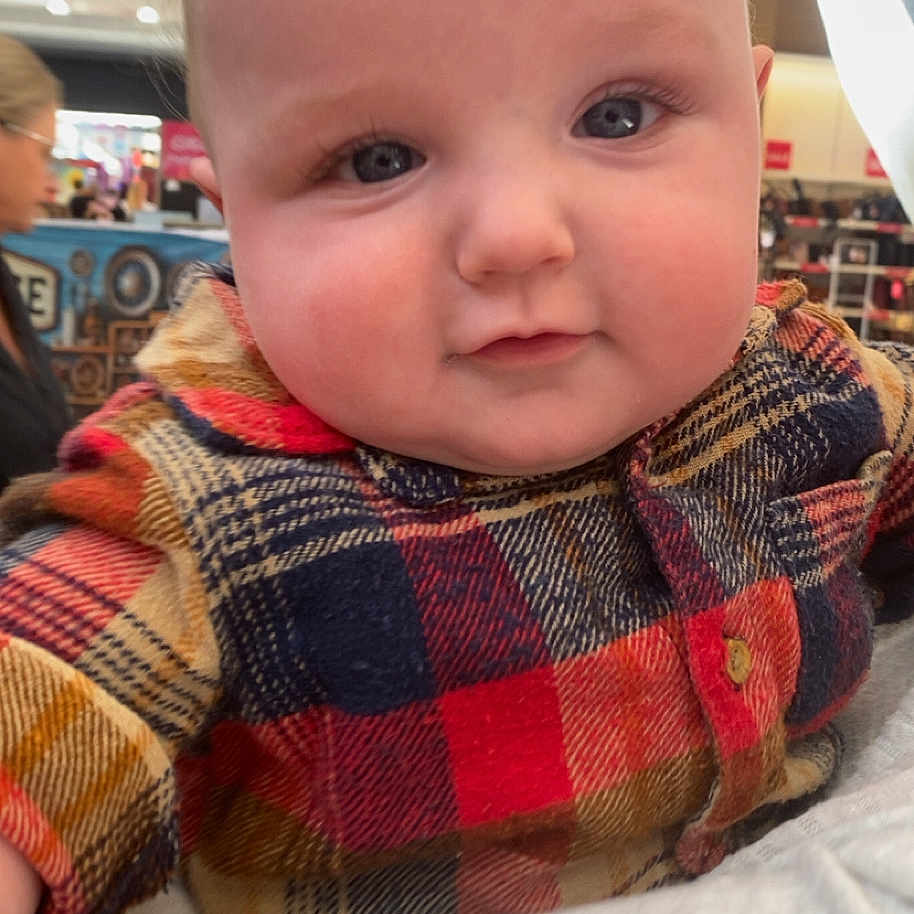 Jhekoá joined the competition — help win amazing prizes! baby, background_blur, bright_eyes, casual, child, chubby_cheeks, closeup, clothing, curious, cute, face, indoor, infant, pattern, person, plaid_shirt, portrait, shopping_mall, soft_lighting, young_child