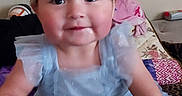 Lina joined the competition — help win amazing prizes! toddler, child, smiling, blue_dress, pigtails, indoor, hand_holding, couch, cushion, person, face, happy, cute, young_child, portrait, home, patterned_fabric, sitting, playful, baby