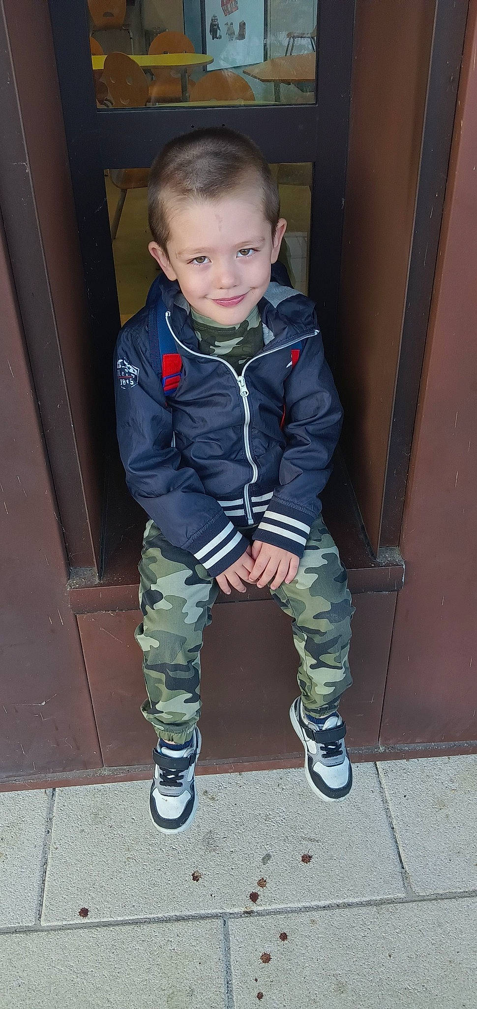 Kélyo a rejoint le concours — aidez-le/la à gagner de superbes lots ! baby_toddler_clothing, camouflage, child, denim, electric_blue, head, human_leg, joy, knee, military_camouflage, outdoor_shoe, pattern, person, shoe, sitting, sleeve, smile, sneakers, standing, thigh