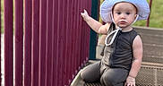 Aemond joined the competition — help win amazing prizes! toddler, child, hat, playground, metal_platform, pink_bars, outdoor, grass, serious_expression, sitting, daylight, person, clothing, play_area, summer, young_child, cute, kid, mesh_surface, sunhat