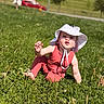Aemond is registered to the contest to win money with this photo: toddler, child, grass, outdoor, sunhat, red_clothing, greenery, sunlight, nature, baby, grass_field, daylight, exploring, crouching, cute, person, playing, summer, hat, young_child