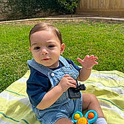 Zain joined the competition — help win amazing prizes! baby, backyard, blanket, blue_shirt, child, cute, denim_overalls, fence, grass, greenery, happy, outdoor, person, playing, sitting, sock, summer, sunlight, toddler, toy