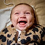 baby, baby_clothes, button, cardigan, cheerful, child, closeup, clothing, cute, face, happy, indoor, infant, leopard_print, lying_down, person, portrait, smile, soft_texture, warm_colors