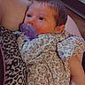 baby, infant, child, portrait, pacifier, floral_dress, leopard_print, cushion, reclining, indoors, home, sitting, face, eyes, hair, cozy, casual, closeup, photography, safe