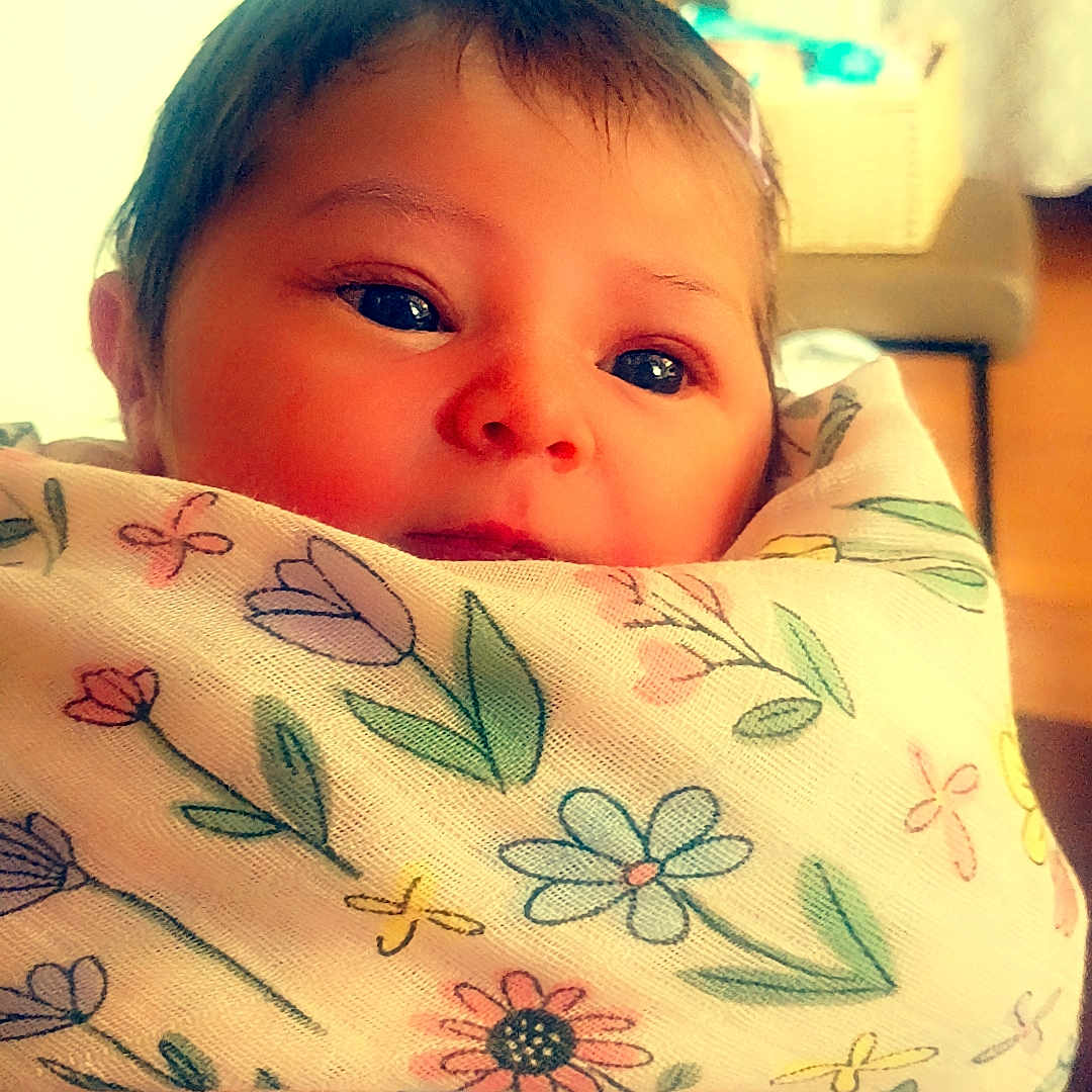 Izabelle joined the competition — help win amazing prizes! baby, child, blanket, floral_pattern, wrapped, face, eyes, indoors, soft_light, portrait, cute, infant, warm, cozy, person, newborn, expression, head, skin, young