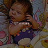 baby, bed, bedding, blanket, cartoon, child, colorful, ear, eyes, face, floral, hair, hand, indoors, infant, lying_down, newborn, portrait, sleepy, timestamp