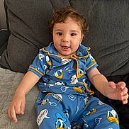Valentino joined the competition — help win amazing prizes! toddler, child, smiling, pajamas, donald_duck, blue_clothing, curly_hair, couch, cushions, indoor, happy, face, person, seated, home, comfort, cute, young_child, playful, relaxed