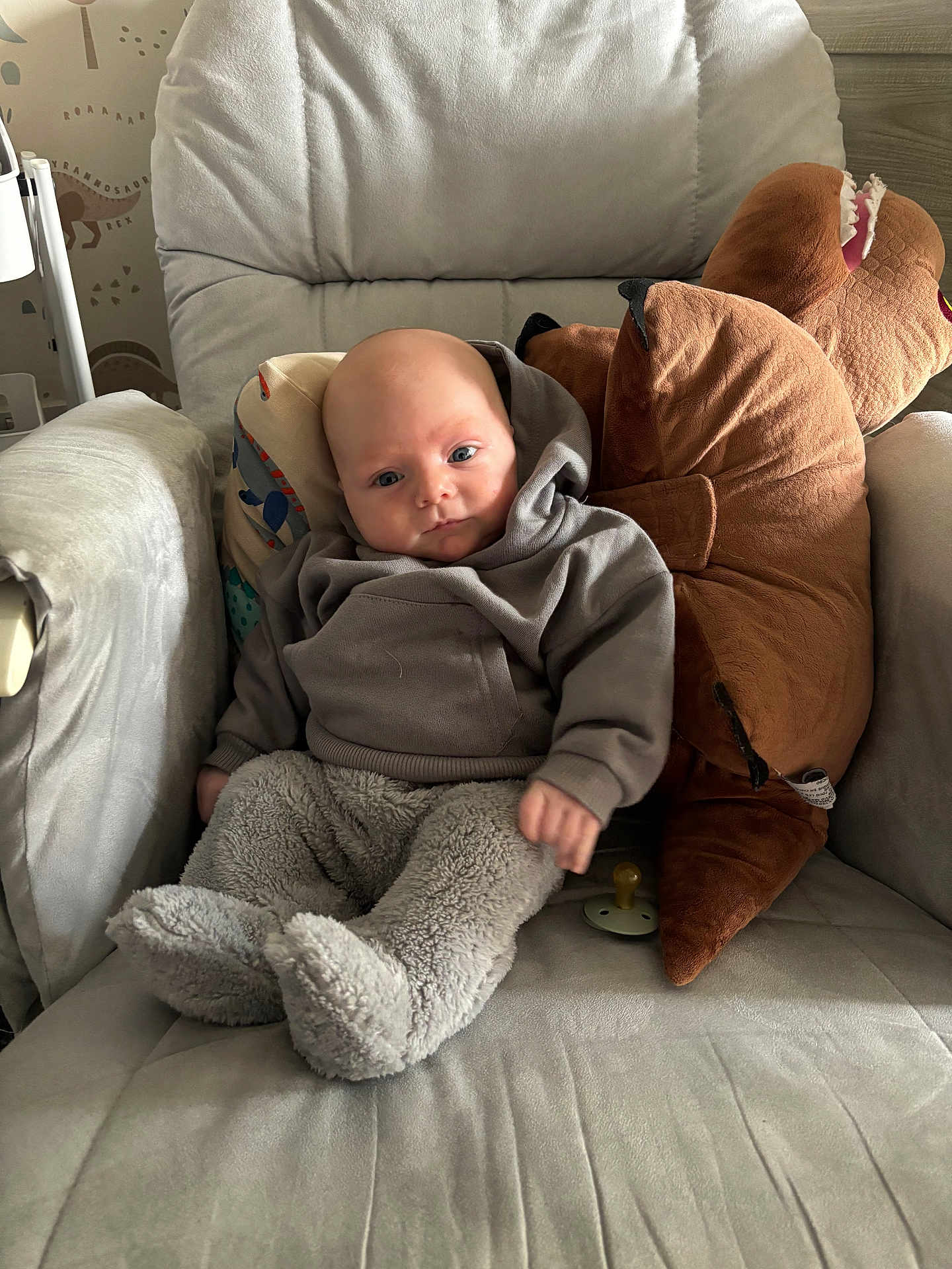 Oscar joined the competition — help win amazing prizes! baby, child, plush_toy, dinosaur, armchair, pillow, hoodie, fuzzy_pants, pacifier, indoor, soft_toys, cute, childrens_room, seated, comfort, portrait, furniture, young_child, cozy, smiling