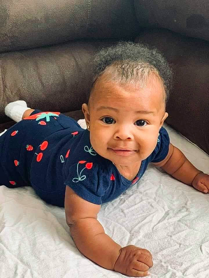 Semariah is registered to the contest to win money with this photo: baby, baby_crawling, baby_toddler_clothing, bed_sheet, cheek, child, comfort, couch, crawling, finger, linens, living_room, person, skin, toddler, tummy_time