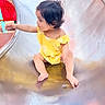 toddler, child, playground, slide, yellow_outfit, sitting, curly_hair, face, smiling, outdoor, reaching, baby, portrait, metal, shiny_surface, play, adventure, barefoot, colorful, daylight