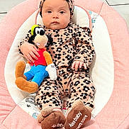 Claudia joined the competition — help win amazing prizes! baby, infant, plush_toy, pink, cushion, headband, slippers, floor, tile, clothing, person, indoor, seat, toy, hand, face, looking_at_camera, cute, child, soft