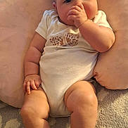 Elaine joined the competition — help win amazing prizes! baby, carpet, chubby_arms, chubby_legs, comfort, cozy, curious_expression, cushion, face, head, indoors, infant, person, pillow, seated, skin, socks, soft_texture, thumb_sucking, white_onesie