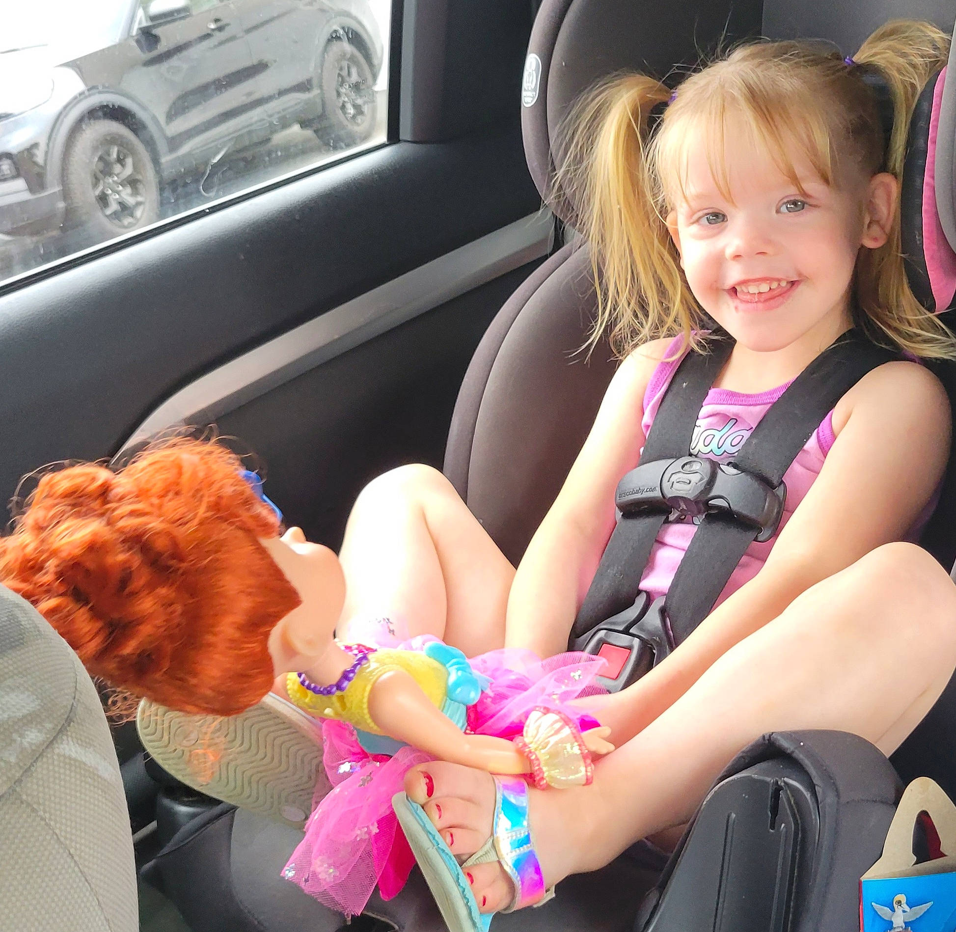 Viviana is registered to the contest to win money with this photo: auto_part, automotive_design, automotive_exterior, car, car_seat, car_seat_cover, dress, finger, hair, hairstyle, hand, joy, motor_vehicle, person, seat_belt, smile, steering_part, steering_wheel, tire, toddler