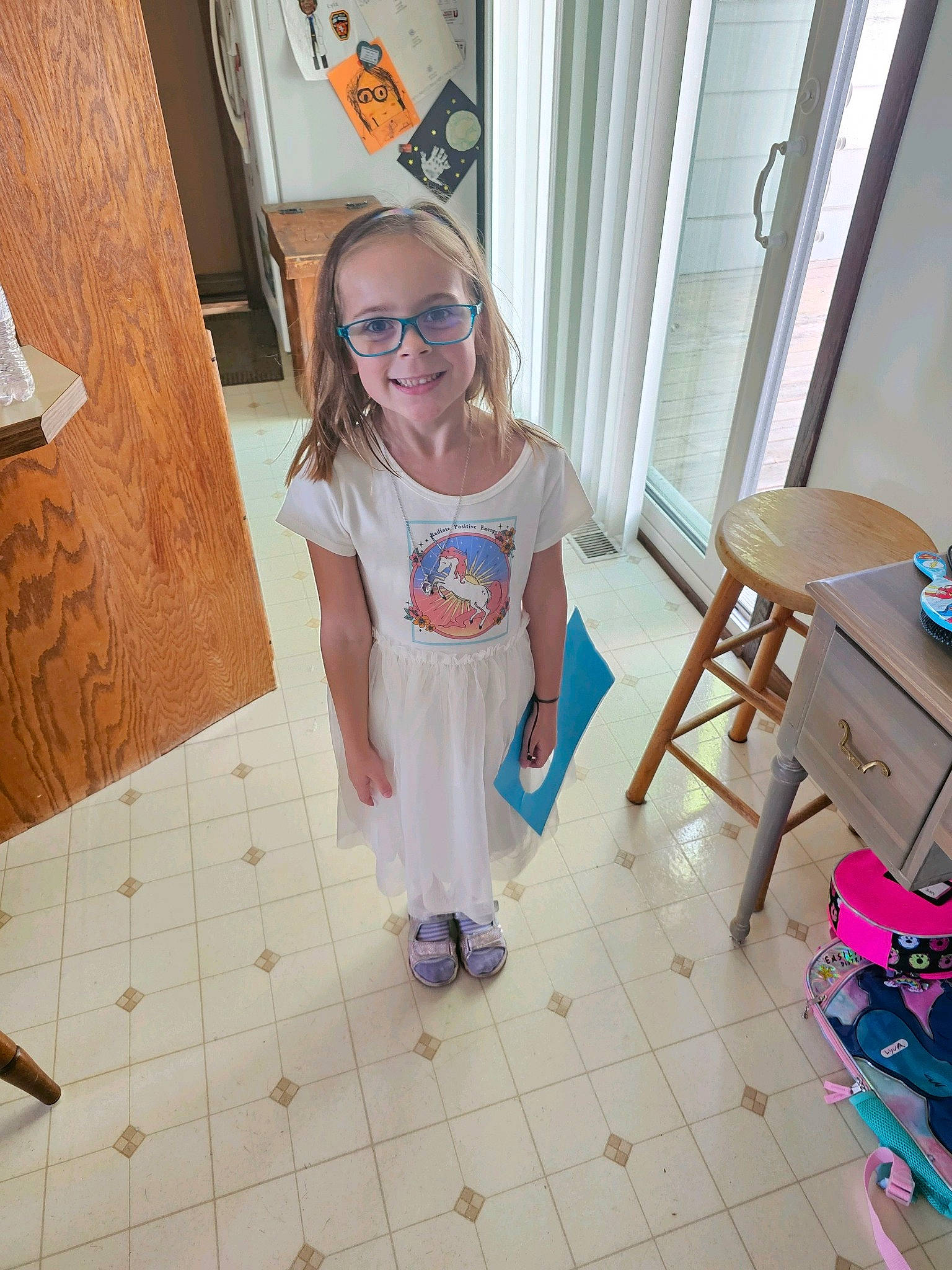 Lyla joined the competition — help win amazing prizes! baby_toddler_clothing, child, door, eyewear, floor, flooring, fun, goggles, hardwood, human_leg, joy, office_supplies, person, sitting, smile, standing, sunglasses, table, toddler, vision_care