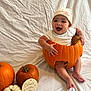 baby, pumpkin, halloween, hat, white_background, smiling, infant, holiday, orange, white_pumpkin, plaque, celebration, child, cute, festive, sitting, face, hands, feet, costume