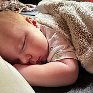 Brandon is registered to the contest to win money with this photo: baby, sleeping, blanket, pillow, infant, cute, peaceful, resting, soft, cozy, child, face, skin, arm, closeup, indoors, comfort, relaxation, nap, serene